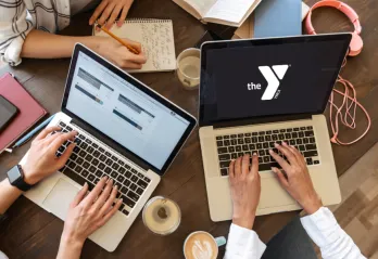 People working in a group around several laptops