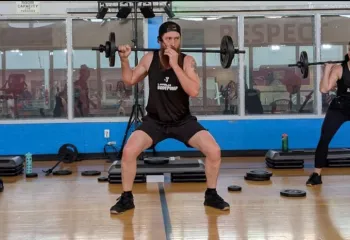 Three Bodypump instructors leading group exercise class
