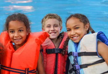 children in lifejackets in the pool