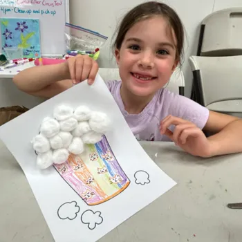 girl in a childcare setting sharing a coloring page craft