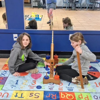 Two children sitting on the floor playing a giant game
