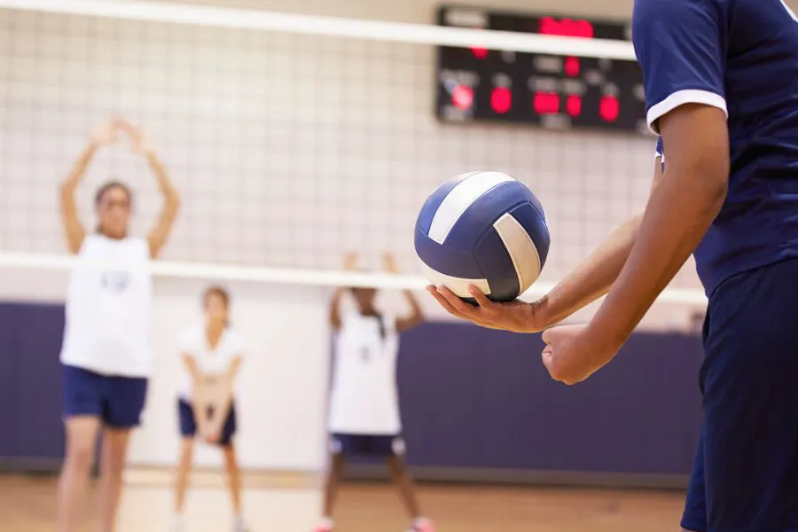 Boys playing volleyball in a gymnasium