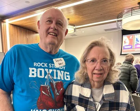 A man in a Rock Steady Boxing tshirt with his wife