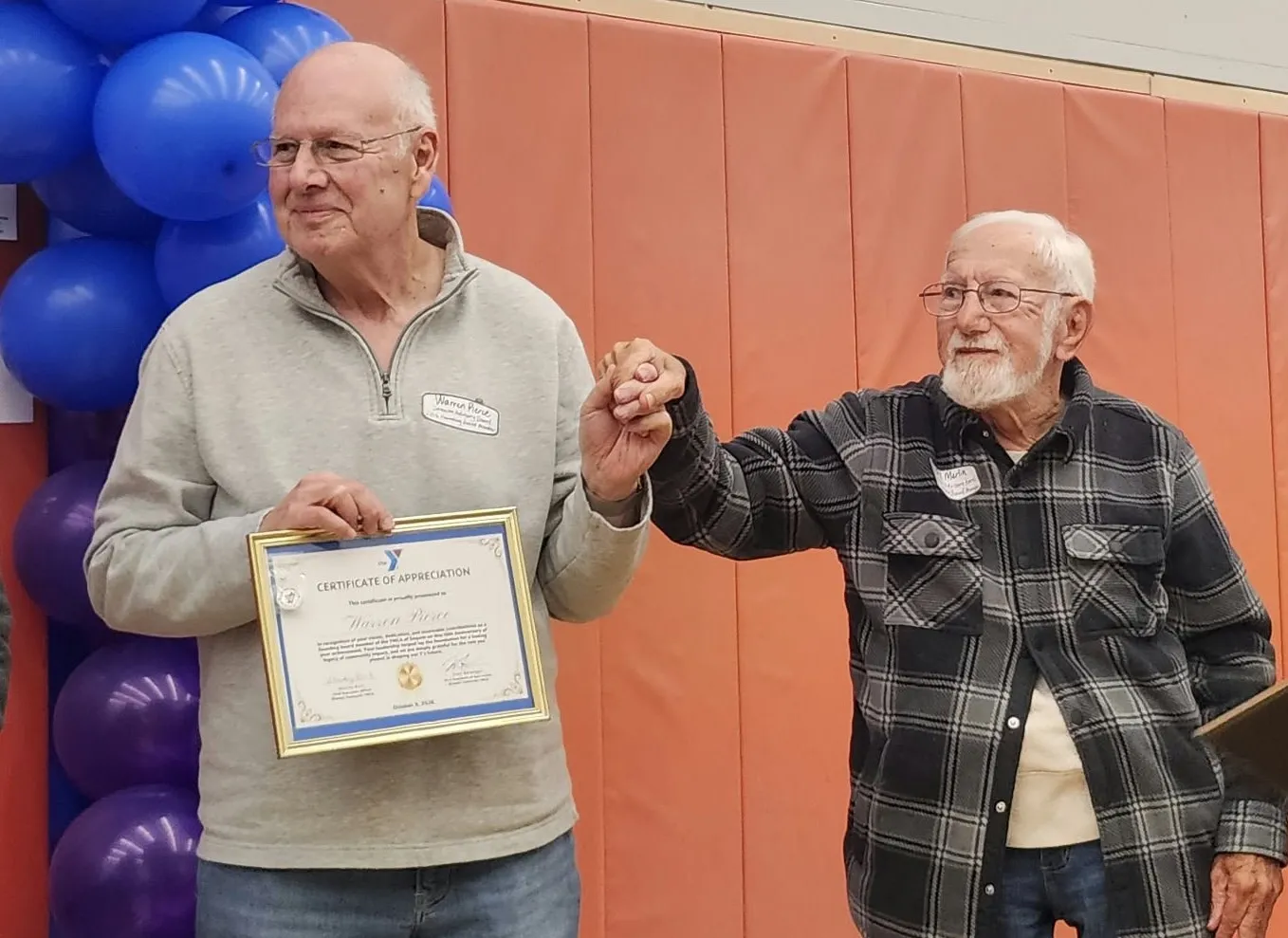 Two gentlemen who were founding members holding certificates of appreciation.