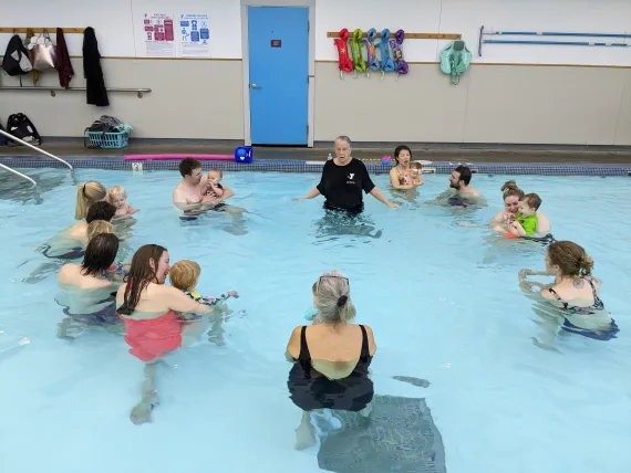 Parents in the shallow pool with infants in a circle