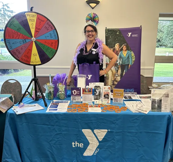 Woman wearing a crown at a vendor event at a YMCA table