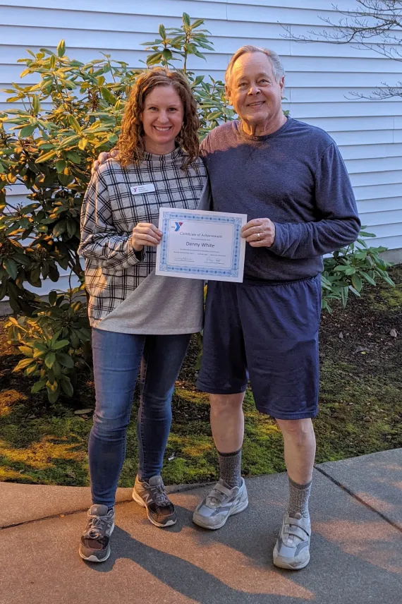 woman handing a man a certificate of appreciation for volunteering