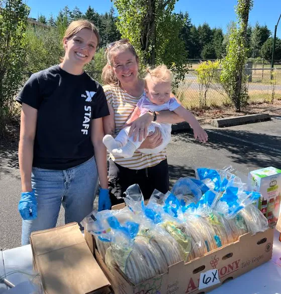 two women at a summer meal distribution volunteering ymca