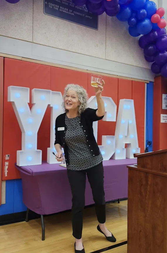 A woman giving a toast an at event.