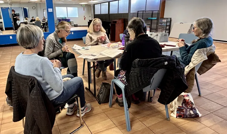 A group of women knitting and crocheting.