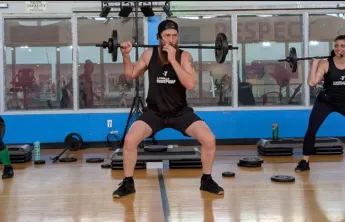 Three Bodypump instructors leading group exercise class