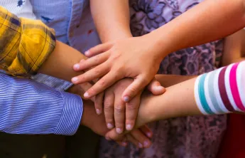 Photo of children's hands in a circle
