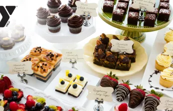 A stock image of a variety of desserts on a display table.
