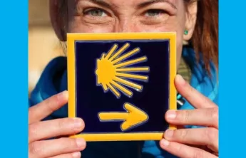 A woman holding a tile of a sun with an arrow.