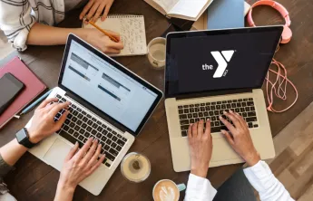 People working in a group around several laptops