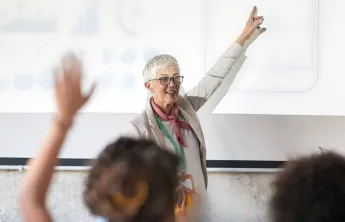 A person raising their hand at a presentation.