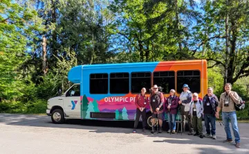 Group of Senior Adults gathered around the Y van in the woods