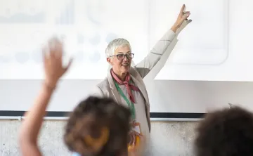 A person raising their hand at a presentation.