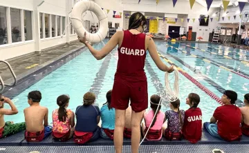A lifeguard demonstrating skills to children at the pool.